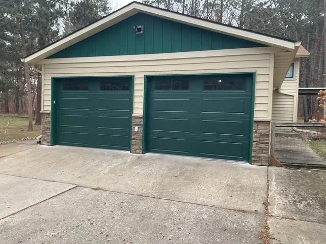 Two green carriage-style garage doors on a Midwest detached garage