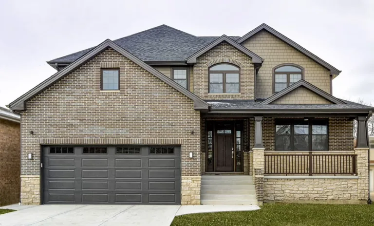 Dark gray long-panel garage door on a brick two-story home